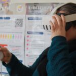 une femme ayant un casque de réalité virtuel et une manette en main.