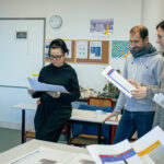 plusieurs personnes se tenant debout, en lisant des documents